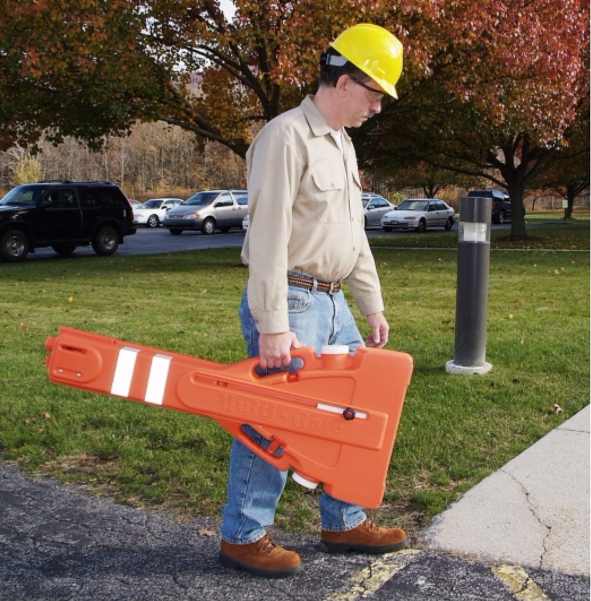 Worker carrying a Multi-Gate barrier by its handles