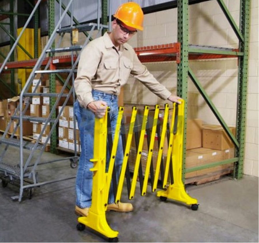 Worker deploying an Xpandit barricade in a warehouse